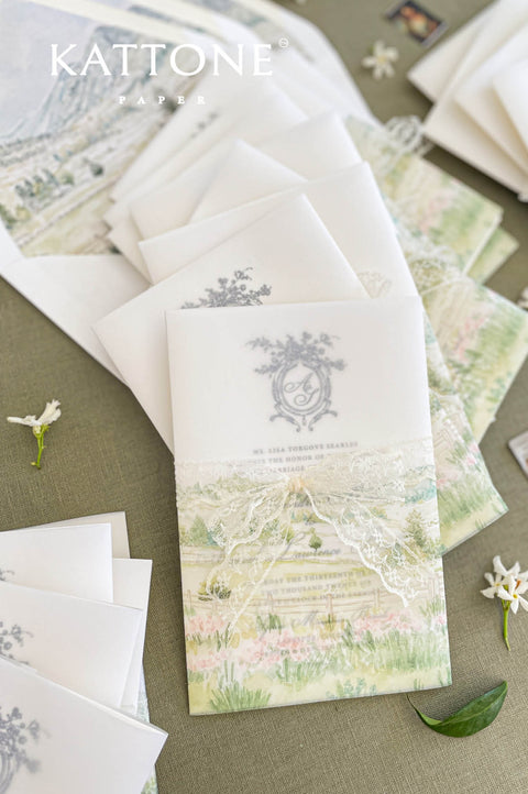 Close up of vellum wrap wedding invitation showing translucent overlay and watercolor scenery.