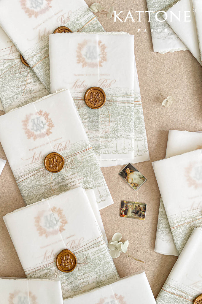Soft translucent vellum wedding invitation cover layered over handmade cotton paper and finished with a wax seal for a refined and romantic presentation.