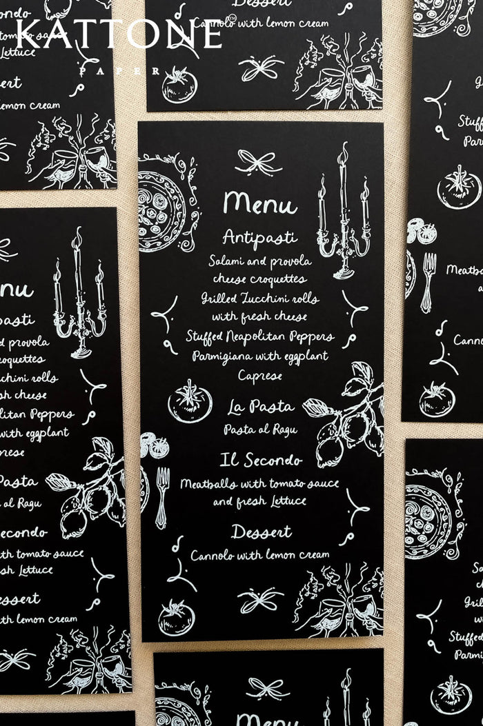 Black wedding menus with whimsical hand-drawn wedding icons and white typography, styled for a modern reception.