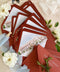 Red wedding envelopes with printed guest addresses and illustrated envelope liners, crafted from premium paper for luxury fine art invitation suites.