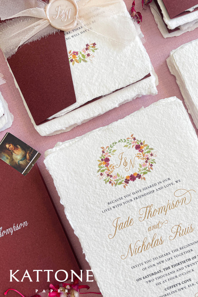 Close-up of handmade cotton paper wedding invitation showing textured deckle edges and refined lettering.