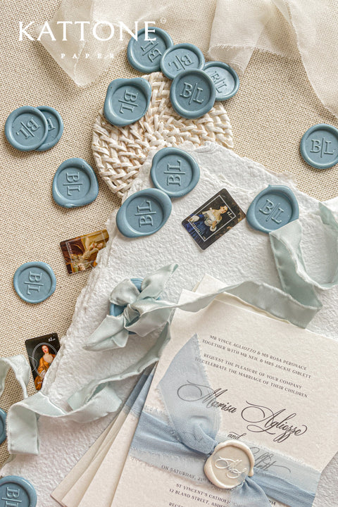 Elevate your stationery with these handcrafted dusty blue wax seals, designed to add a soft, timeless accent to fine art invitations. Each seal is individually poured and stamped with a classic monogram, creating a refined detail that feels elegant, tactile, and intentionally made. The muted blue tone pairs beautifully with handmade paper, silk ribbons, and neutral palettes, making these wax seals a perfect finishing touch for weddings and bespoke paper goods.