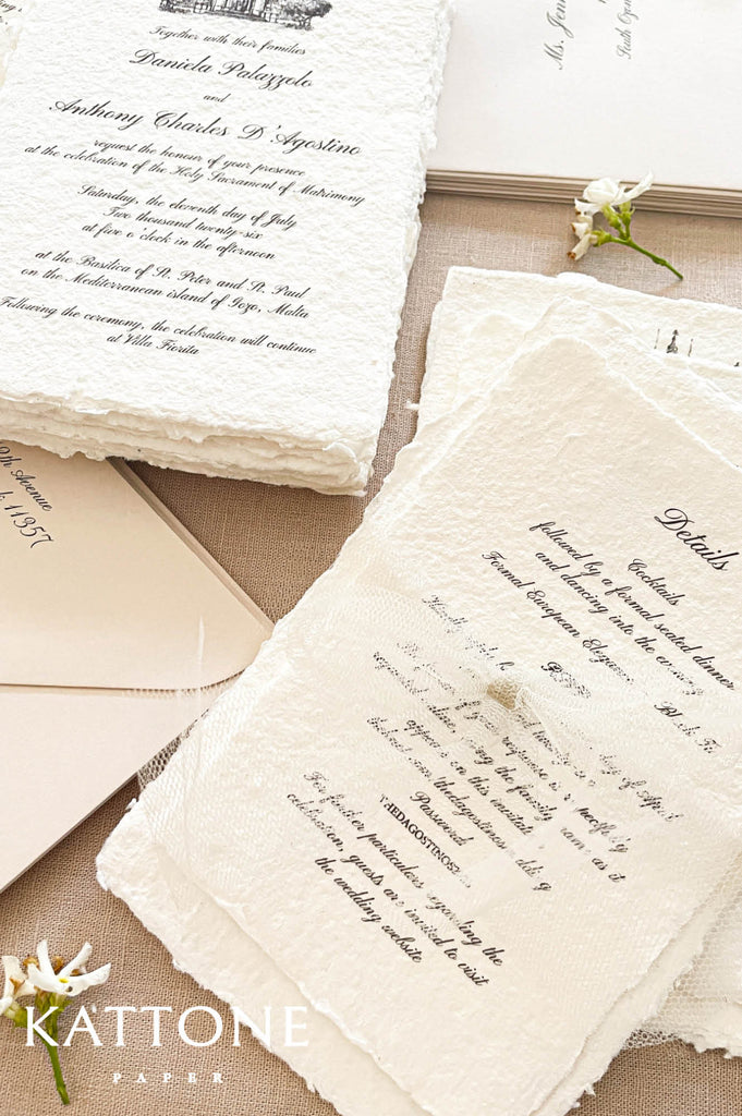 Close up of textured handmade cotton paper invitation showing organic deckled edges, fine architectural line drawing and elegant typography.