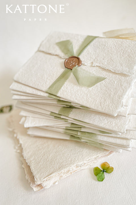 This exquisite trifold wedding invitation set offers a blend of modern design and personalized artistry. Each handmade paper invitation features a beautifully hand-painted custom watercolor monogram of your initials, creating a unique and personal touch. The convenient trifold design offers ample space for all your wedding details, all wrapped in a beautifully elegant package that your guests will adore.