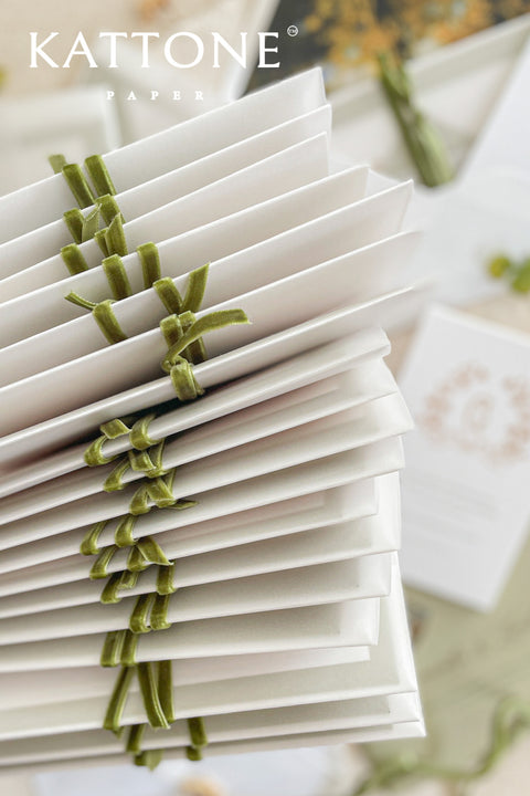 Elegant, timeless, and infused with personal charm - this wedding invitation suite was designed to announce your celebration with sophistication and warmth. Printed on luxury cotton paper. The suite features a beautifully hand-drawn monogram, symbolizing the union of two names in an artful botanical wreath. A romantic script font paired with refined serif text brings balance and grace, while vellum jackets and olive ribbons add layers of soft, organic beauty.