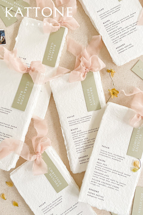 Elevate your tablescape with our handmade paper wedding menus with personalized name tags, crafted from soft cotton paper with naturally deckled edges. Each menu exudes fine-art elegance, featuring delicate typography, custom color tags, and flowing chiffon ribbons - blending romance, craftsmanship, and sophistication. Perfect for luxury, garden, and destination weddings, these menus double as keepsake place cards.