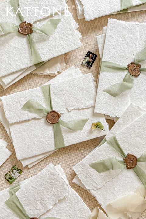 This exquisite trifold wedding invitation set offers a blend of modern design and personalized artistry. Each handmade paper invitation features a beautifully hand-painted custom watercolor monogram of your initials, creating a unique and personal touch. The convenient trifold design offers ample space for all your wedding details, all wrapped in a beautifully elegant package that your guests will adore.