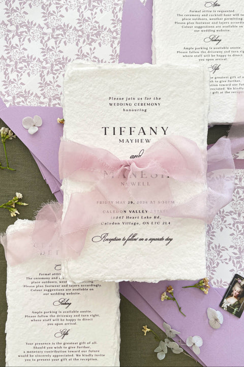 Fine art wedding invitation suite styled with handmade paper invitations, blush silk ribbon, lavender envelopes and patterned liners.