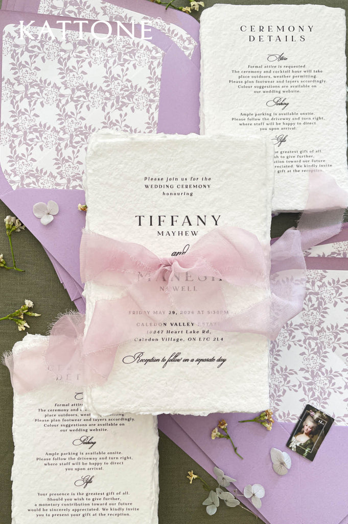 Fine art wedding invitation suite styled with handmade paper invitations, blush silk ribbon, lavender envelopes and patterned liners.