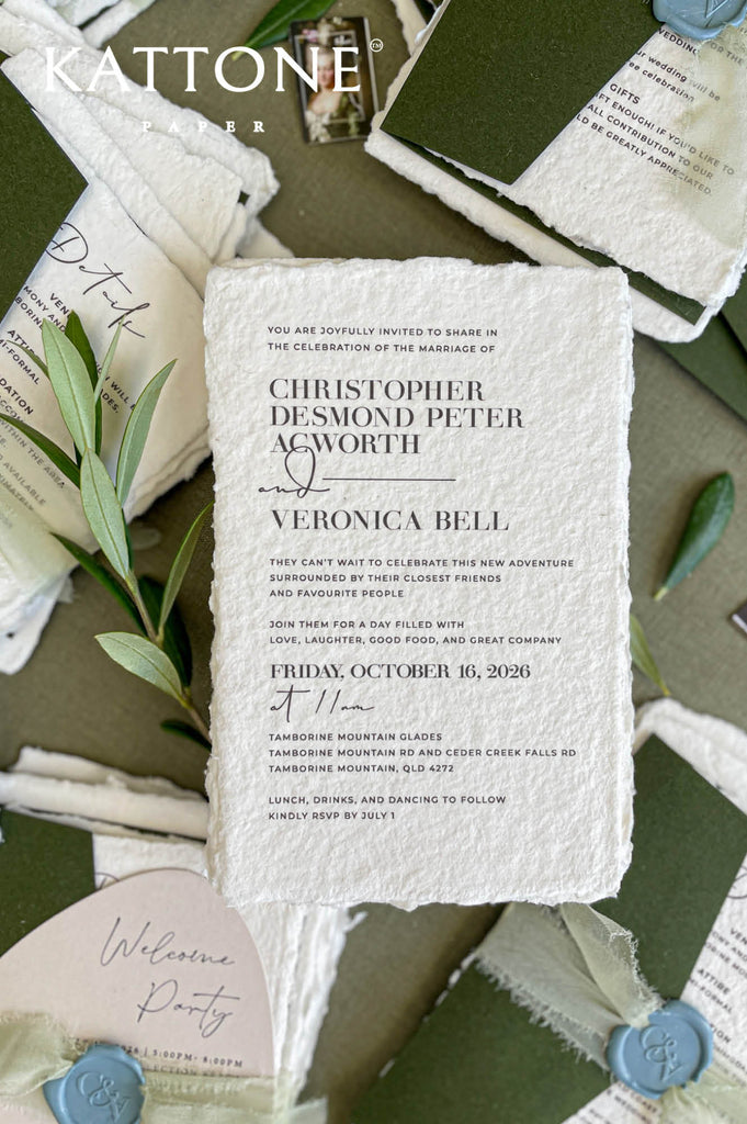 Close-up of handmade cotton paper wedding invitation featuring textured deckle edges and refined modern typography.