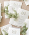 Wedding ceremony program with custom watercolor monogram and soft botanical greenery.