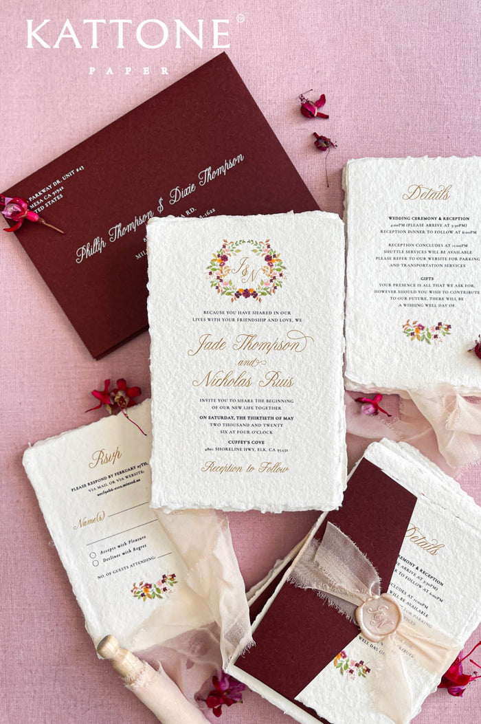 Handmade paper wedding invitations with deckle edges, elegant typography, and luxury wedding stationery styling.