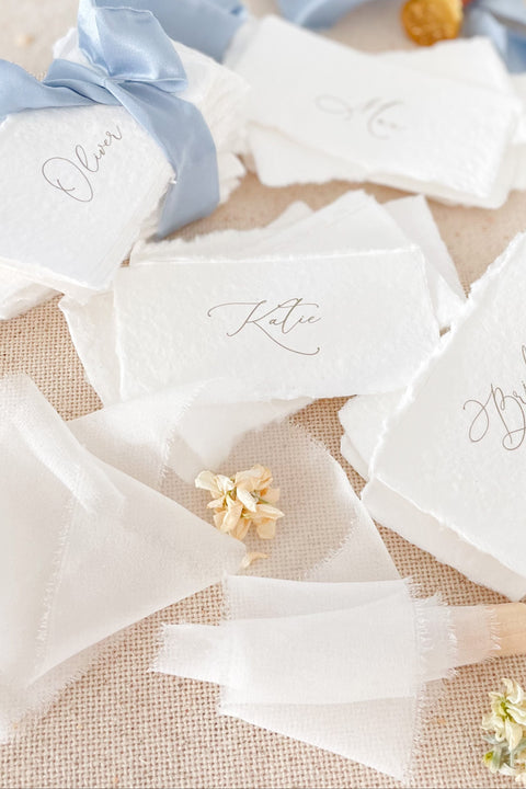 Create a soft, elegant tablescape with our handmade paper place cards, crafted from premium cotton rag paper and finished with naturally torn deckled edges. Each card showcases refined calligraphy and a romantic, fine-art aesthetic - perfect for weddings, rehearsal dinners, intimate parties, and luxury celebrations. Designed to elevate your guest seating display, these artisan-crafted cards bring texture, charm, and timeless beauty to any event.