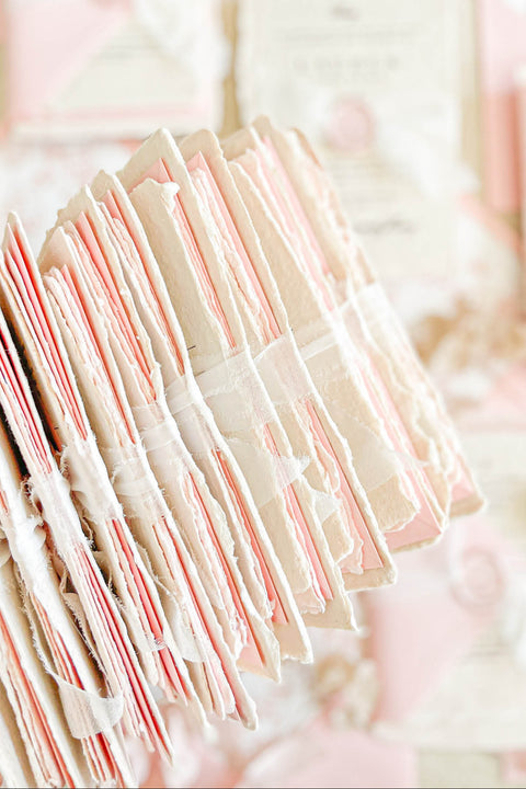 This handmade paper wedding invitation suite exudes timeless elegance with a touch of modern artistry. Crafted on luxury cotton paper with deckled edges, each invitation tells a story of care and craftsmanship. The delicate texture pairs beautifully with blush and ivory tones, creating a look that feels both classic and ethereal. Every detail is completed with a wax seal monogram, adding a touch of old-world refinement.