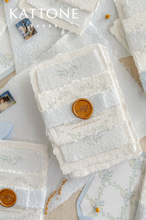 Embrace bohemian charm and natural elegance with the Alcina boho rustic stationery sets. Each handmade wedding invitation is a beautiful work of art, featuring luxurious cotton rag paper with a romantic deckle edge. To complete the bohemian feel, every suite is embellished with a delicate tassel, creating a uniquely personal and tactile experience for your guests. The combination of rustic textures and charming details makes this collection perfect for a relaxed and romantic celebration.