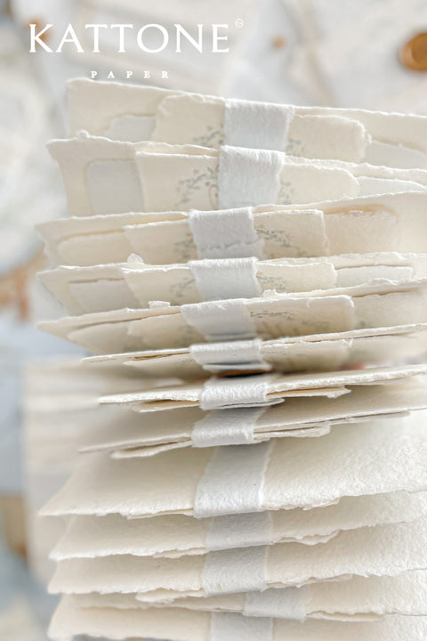Embrace bohemian charm and natural elegance with the Alcina boho rustic stationery sets. Each handmade wedding invitation is a beautiful work of art, featuring luxurious cotton rag paper with a romantic deckle edge. To complete the bohemian feel, every suite is embellished with a delicate tassel, creating a uniquely personal and tactile experience for your guests. The combination of rustic textures and charming details makes this collection perfect for a relaxed and romantic celebration.