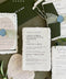 Handmade paper wedding invitation suite with deckle edges, forest green envelopes, wax seal, and modern elegant typography.
