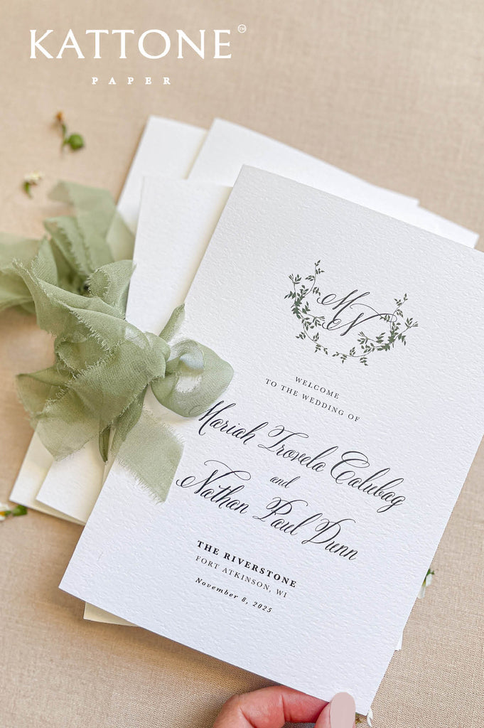 Stacked botanical wedding programs with monogram design for garden wedding stationery.