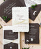 Handmade paper wedding invitation with deckled edges, charcoal envelope, silk ribbon wrap, elegant black tie wedding stationery flat lay.