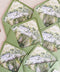 Pear green wedding envelopes with watercolor venue envelope liners styled on neutral linen with wax seals and fine art stationery details.