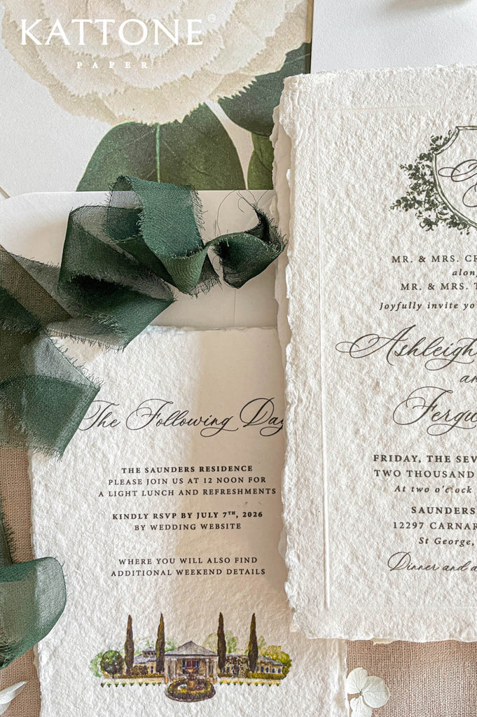 Handmade cotton paper wedding invitation with naturally deckled edges featuring elegant script typography and delicate botanical crest illustration.