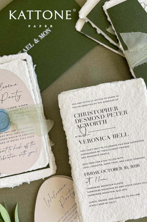 Close-up of handmade cotton paper wedding invitation featuring textured deckle edges and refined modern typography.
