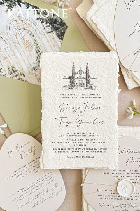 Romantic wedding stationery styling with greenery, handmade paper, and custom watercolor venue invitations.