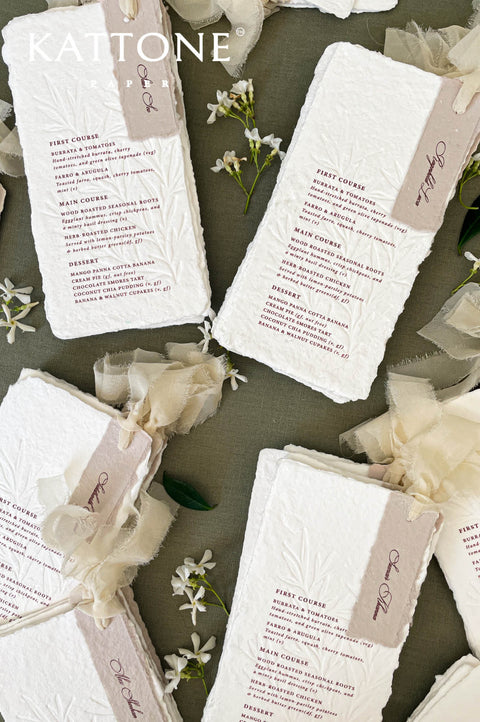 Stacked handmade paper wedding menus showcasing organic torn edges and artisanal paper texture.