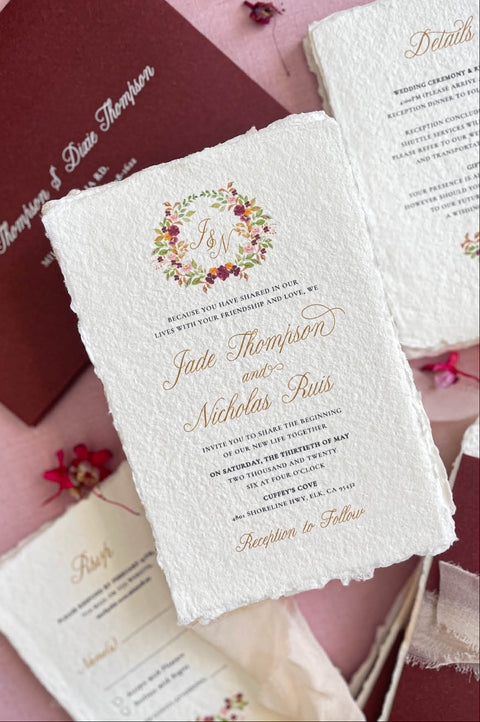 Close-up of handmade cotton paper wedding invitation showing textured deckle edges and refined lettering.