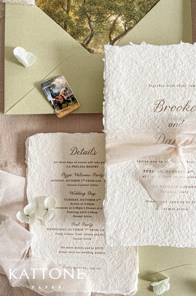 Soft ivory chiffon ribbon wrapped around handmade paper wedding invitations adds movement, softness, and romantic layered styling.