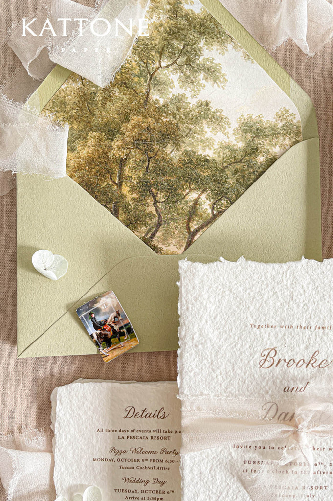 Sage green envelopes with custom scenic liners featuring fine art landscape artwork create a beautifully cohesive and elevated presentation.