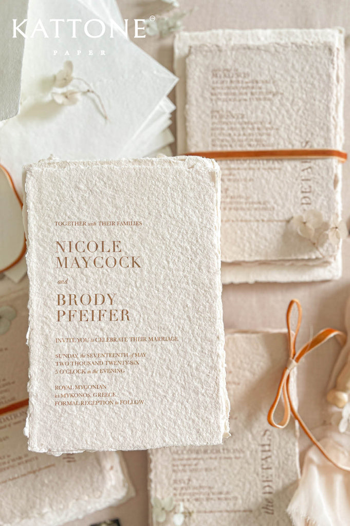 Complete luxury wedding invitation suite including handmade paper cards, inserts, envelopes and ribbon accents.