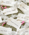 Handmade paper wedding place cards with deckled edges and soft silk ribbon, fine art table styling with blush florals.