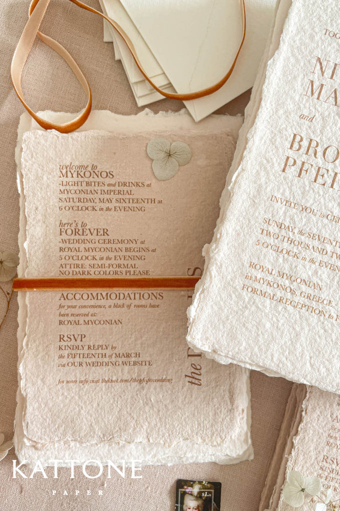 Handmade cotton paper with visible fibers and naturally torn deckled edges creating a rich artisanal texture.
