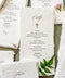 Handmade paper wedding menu with deckled edges, personalized guest name, elegant icon motif, fine art reception stationery flat lay.