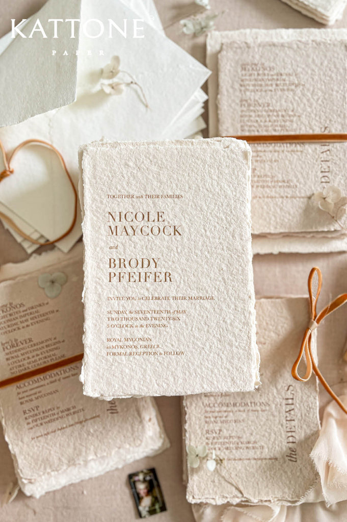 Complete luxury wedding invitation suite including handmade paper cards, inserts, envelopes and ribbon accents.