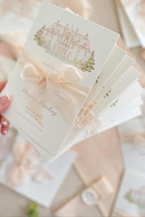 Announce your wedding with timeless artistry through our Save the Date cards, featuring a hand-painted watercolor illustration of your wedding venue and tied with a soft blush silk ribbon. Printed on luxury fine-art paper, each card captures the romance, charm, and craftsmanship that make your wedding story unique. Perfect for fine-art, estate, or destination weddings, this design combines classic elegance with a personal, meaningful touch.
