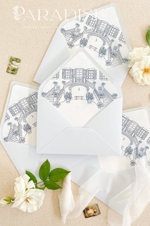 Luxury baby blue envelopes featuring watercolor liners, arranged with floral details for elegant wedding invitations.