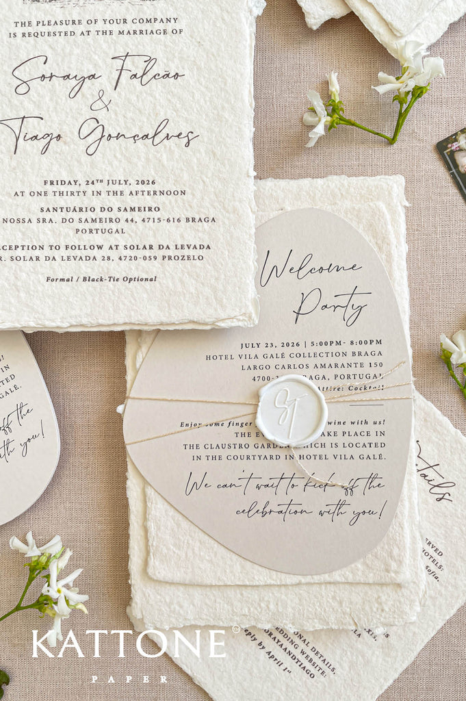 Close-up of handmade cotton paper wedding invitation featuring a watercolor illustration of a European wedding venue.