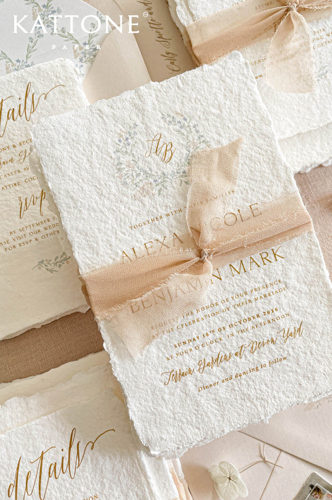 Premium handmade paper wedding invitation suite with botanical monogram artwork, custom floral envelope liners, deckled edge cotton paper, and blush chiffon ribbon for elegant romantic weddings.