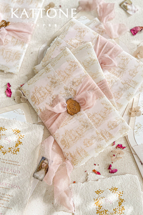 This exquisite wedding invitations suite offers a blend of timeless charm and personalized artistry. The suite features beautiful pretty stationery enclosed in a translucent custom toile de jouy vellum jacket, printed with your unique custom crest monogram. The result is a truly elegant and memorable keepsake that sets a romantic and intimate tone for your special day.