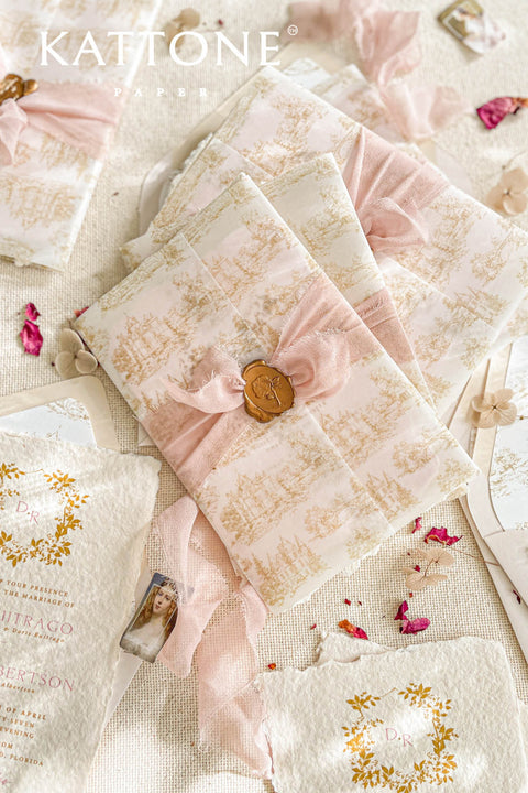 This exquisite wedding invitations suite offers a blend of timeless charm and personalized artistry. The suite features beautiful pretty stationery enclosed in a translucent custom toile de jouy vellum jacket, printed with your unique custom crest monogram. The result is a truly elegant and memorable keepsake that sets a romantic and intimate tone for your special day.