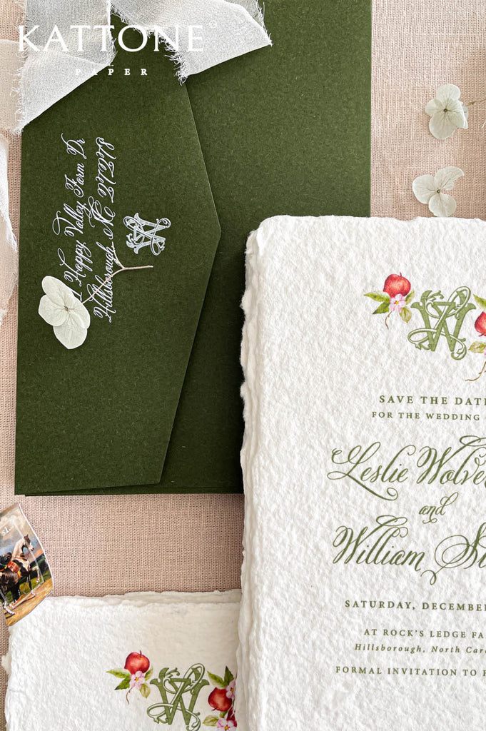 Dark green wedding envelopes with white calligraphy and soft chiffon ribbon styled with handmade paper save the dates.