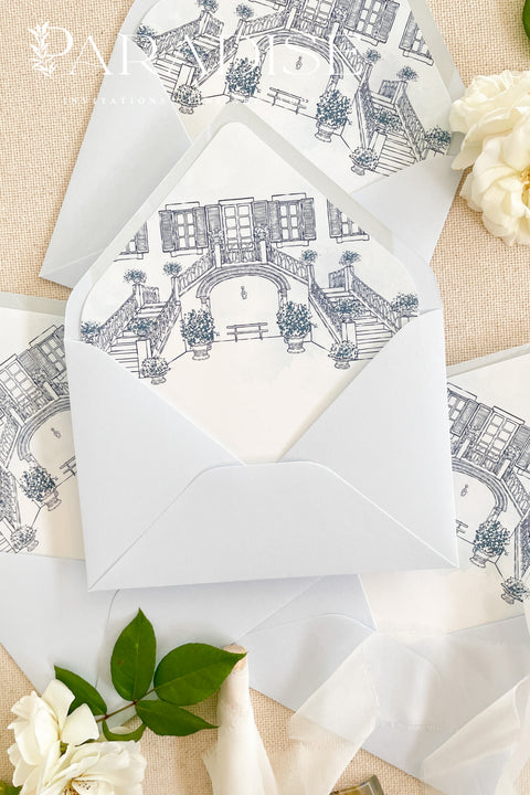 Baby blue envelopes with watercolor envelope liners, styled with white flowers for fine art wedding stationery.