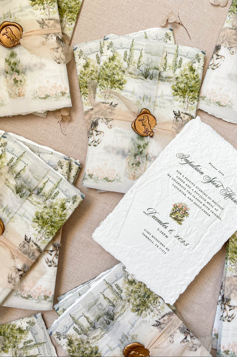 Fine-art wedding stationery styling with embossed handmade paper invitations, vellum wraps, and custom watercolor designs.