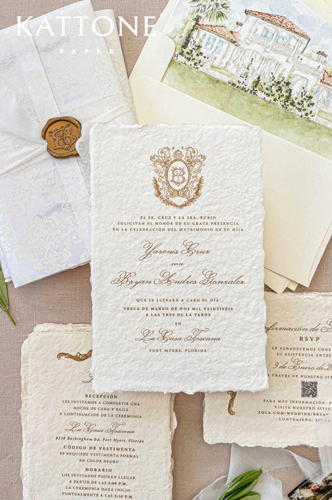 Close-up of handmade cotton paper wedding invitation with natural deckled edges, soft paper texture, elegant gold typography.