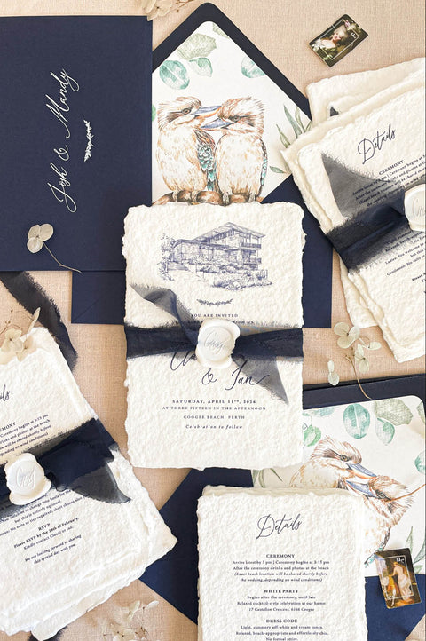Luxury handmade cotton paper wedding invitation with deckled edges and venue illustration, styled with black silk ribbon, wax seal and navy envelopes with illustrated inserts.