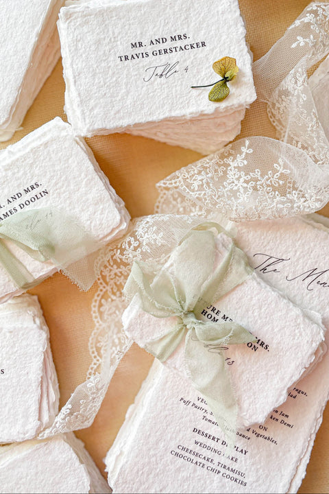 Add refined, old-world elegance to your event with our handmade paper place cards, crafted from luxurious cotton rag paper and finished with naturally torn deckled edges. Each card features elegant serif typography and optional soft green ribbon, creating a timeless fine-art aesthetic perfect for weddings, rehearsal dinners, and sophisticated celebrations. Their artisanal texture, organic silhouette, and customizable details bring beauty and authenticity to every tablescape.