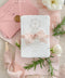 A soft and elegant christening invitation crafted from luxurious handmade paper and finished with a blush chiffon ribbon. Featuring a delicate watercolor floral wreath and subtle Christian cross, this design beautifully celebrates faith, innocence, and new beginnings. Perfect for baptisms, christenings, and church ceremonies, it creates a heartfelt keepsake your family will treasure.