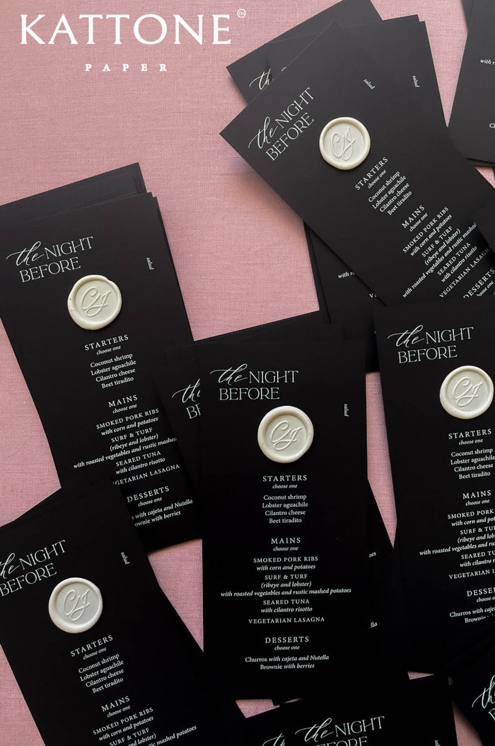 Black wedding menus with modern white typography and custom wax seal detail, styled for a rehearsal dinner or welcome event.